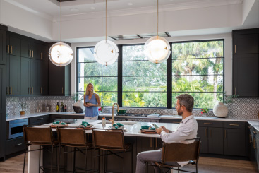 Modern kitchen in South Florida featuring hurricane impact windows providing natural light and storm protection.